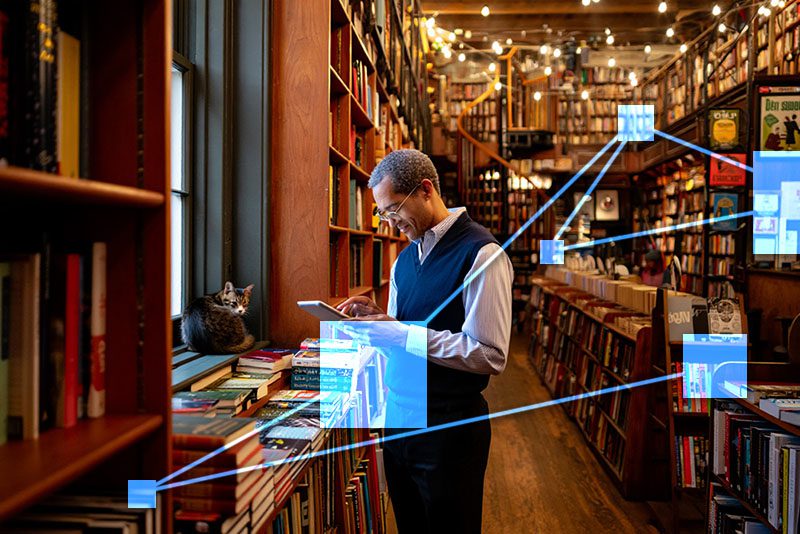 Bookstore manager with TVI software checking over his inventory which is integrated in real-time to accounting. 
