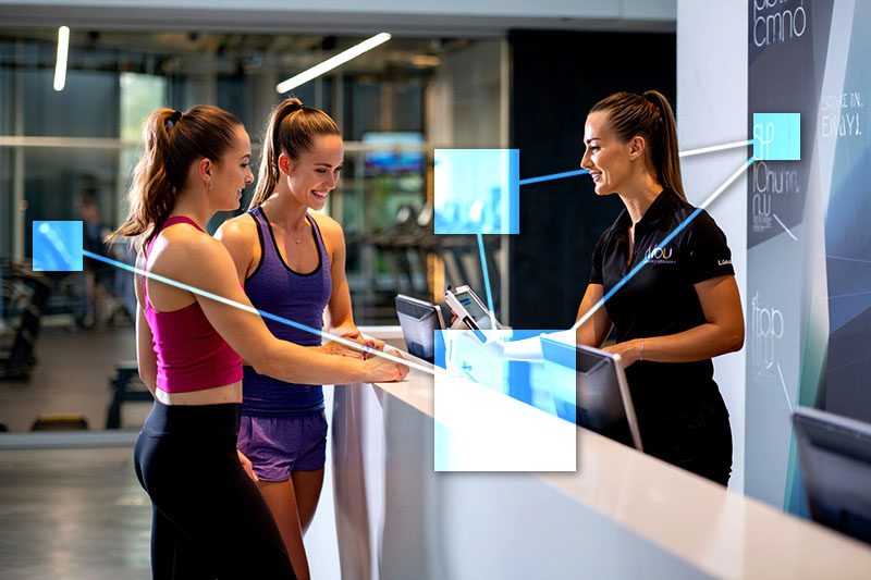 Gym employee checking in a member and member guest at front desk using TVI integrated POS and CRM system. 
