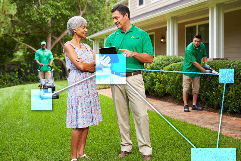Lawn care representative with TVI on laptop speaking with homeowner - TVI has integrated CRM attached to sales for promotions and repeat service orders. 