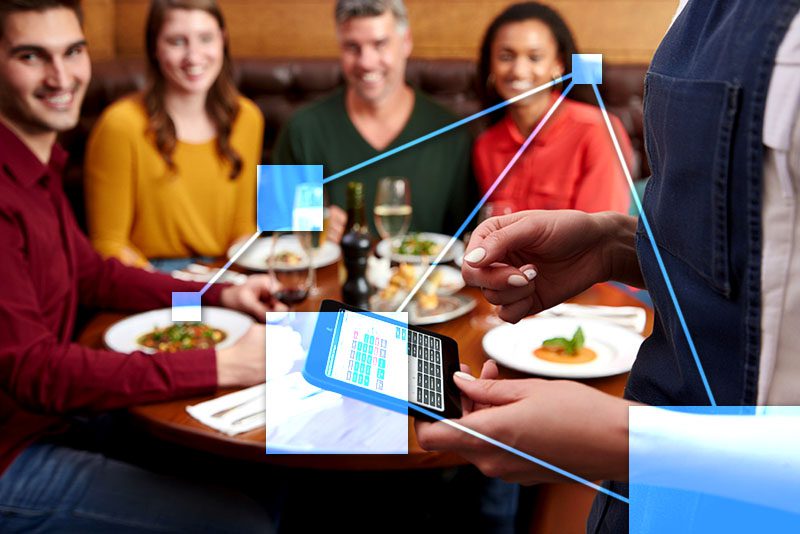 Server using tablet with TVI to take orders in busy dining establishment. 