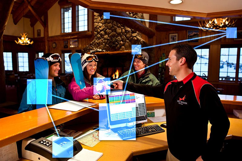 Ski club employee at front desk applying automatic membership renewal and billing. 
