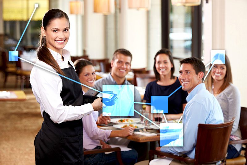 Happy customers in restaurant using TVI POS to settle bill. 